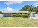 Charming home with a manicured front lawn, tidy hedges, and a bright yellow front door at 895 Joan St, Dunedin, FL 34698