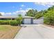 Well-maintained home with lush landscaping, a long driveway, and an attached garage at 895 Joan St, Dunedin, FL 34698