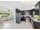 Open kitchen features stainless steel appliances, dark cabinets, and an open view to the living room at 895 Joan St, Dunedin, FL 34698