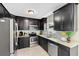 Modern kitchen with dark cabinetry, stainless appliances, and granite countertops at 895 Joan St, Dunedin, FL 34698