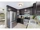 Well-equipped kitchen with stainless steel appliances and dark cabinets, adjacent to the living area at 895 Joan St, Dunedin, FL 34698