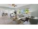 Inviting living room featuring neutral decor, tile floors, and a large window overlooking the landscaped yard at 895 Joan St, Dunedin, FL 34698