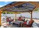Inviting covered patio features stylish seating, a coffee table, and views of the backyard at 895 Joan St, Dunedin, FL 34698