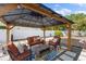 Charming covered patio featuring cozy seating and a view of the beautifully landscaped backyard at 895 Joan St, Dunedin, FL 34698