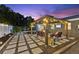 Outdoor patio with a pergola and pavers offers an ideal space for entertaining and relaxation with television at 895 Joan St, Dunedin, FL 34698