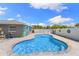Private swimming pool with a mural wall, lush landscaping, and ample seating at 895 Joan St, Dunedin, FL 34698