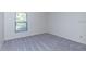 Empty bedroom featuring a window with blinds and neutral carpet at 9220 Dayflower Dr, Tampa, FL 33647
