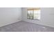 Empty bedroom featuring a window with blinds and neutral carpet at 9220 Dayflower Dr, Tampa, FL 33647