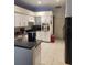 Modern kitchen with white cabinets, black countertops and appliances, and tiled floors at 9220 Dayflower Dr, Tampa, FL 33647