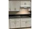 Kitchen featuring modern, sleek white cabinets, black countertop, and modern appliances at 9220 Dayflower Dr, Tampa, FL 33647