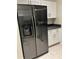 Modern kitchen boasting a stainless steel refrigerator and sleek white cabinetry at 9220 Dayflower Dr, Tampa, FL 33647