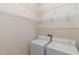 Functional laundry area featuring a washer, dryer, and wire shelving for storage at 9220 Dayflower Dr, Tampa, FL 33647