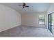 Main bedroom with carpet, fan, and sliding door with pool view at 9220 Dayflower Dr, Tampa, FL 33647
