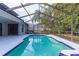A screened-in pool with a spa offers a serene outdoor retreat with lush landscaping and privacy at 9220 Dayflower Dr, Tampa, FL 33647