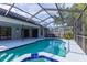 An enclosed pool features an attached spa and outdoor seating, perfect for year-round enjoyment at 9220 Dayflower Dr, Tampa, FL 33647