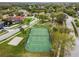 Overhead shot of a tennis court surrounded by green grass, offering a premium sports and recreational amenity at 9220 Dayflower Dr, Tampa, FL 33647
