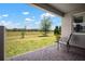 Covered back patio with brick flooring, overlooking a large, green lawn with trees at 923 Whimbrel Run, Bradenton, FL 34212