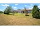 View of the backyard with grass and trees, as well as the home's exterior at 923 Whimbrel Run, Bradenton, FL 34212