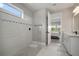 Beautifully tiled walk-in shower with glass enclosure in bathroom with a view to the bedroom at 923 Whimbrel Run, Bradenton, FL 34212