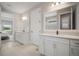 Dual sinks with white cabinets and stylish fixtures in this bright bathroom with tiled floors at 923 Whimbrel Run, Bradenton, FL 34212