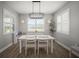 Bright dining room with modern light fixture, plantation shutters, and wood-look flooring at 923 Whimbrel Run, Bradenton, FL 34212