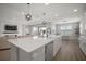 Open concept kitchen and living area, bright and airy with stainless steel appliances, island seating and wood floors at 923 Whimbrel Run, Bradenton, FL 34212