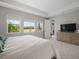 Bright main bedroom featuring three large windows, trey ceiling, and view to the backyard at 923 Whimbrel Run, Bradenton, FL 34212