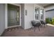 Inviting porch with a green door, brick pavers, modern outdoor chairs and the house number at 923 Whimbrel Run, Bradenton, FL 34212