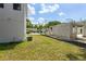 View of backyard with new construction block and lush lawn on a sunny day at 925 E Chelsea St, Tampa, FL 33603