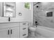 Modern bathroom features a white vanity, marble-look shower, and black fixtures at 925 E Chelsea St, Tampa, FL 33603