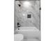 The renovated bathroom includes a shower and bath area with luxurious marble-look tile at 925 E Chelsea St, Tampa, FL 33603