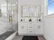 Bathroom featuring a double vanity, gold fixtures, and a glass shower with marble tiles at 925 E Chelsea St, Tampa, FL 33603