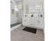 Bathroom featuring a double vanity, gold fixtures, and a glass shower with marble tiles at 925 E Chelsea St, Tampa, FL 33603
