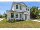 Charming two-story home with white siding, black trim, manicured lawn and driveway at 925 E Chelsea St, Tampa, FL 33603