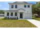 Charming two-story home with white siding, black trim, manicured lawn and driveway at 925 E Chelsea St, Tampa, FL 33603