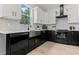 Modern kitchen with white cabinets, black countertops, subway tile backsplash, and stainless steel appliances at 925 E Chelsea St, Tampa, FL 33603