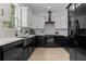 Modern kitchen featuring white cabinets, black countertops, subway tile backsplash and stainless steel appliances at 925 E Chelsea St, Tampa, FL 33603
