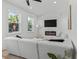 Bright living room with fireplace, TV, modern white sectional, and natural light at 925 E Chelsea St, Tampa, FL 33603