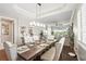 Elegant dining room featuring tray ceilings, a chandelier, and seamless flow into the living space at 1003 Bellasol Way # 9203, Apollo Beach, FL 33572