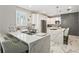 Bright kitchen features white cabinetry, an island with seating, and stainless steel appliances at 1003 Bellasol Way # 9203, Apollo Beach, FL 33572