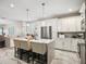 Bright kitchen features white cabinetry, an island with seating, and stainless steel appliances at 1003 Bellasol Way # 9203, Apollo Beach, FL 33572