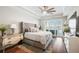 Luxurious primary bedroom with tray ceiling, fan, plush bed, and access to the balcony at 1003 Bellasol Way # 9203, Apollo Beach, FL 33572