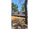 View of a single Gathering home with blue siding on blocks surrounded by a landscape with many trees at 10030 Lake Dr, Weeki Wachee, FL 34613