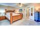 Comfortable bedroom with a wooden frame bed, tile flooring, and a doorway to the bathroom at 10037 62Nd N Ter # 9, St Petersburg, FL 33708