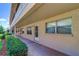 Exterior view of condo with neutral stucco siding, walkway, and green shrubs along the front at 10037 62Nd N Ter # 9, St Petersburg, FL 33708
