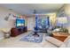 Cozy living room with tile flooring, ceiling fan, decorative touches, and ample natural light at 10037 62Nd N Ter # 9, St Petersburg, FL 33708
