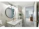 Bathroom with modern vanity, round mirror, and a view into a bedroom with natural light at 10355 Paradise Blvd # 412, Treasure Island, FL 33706