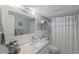 Bright bathroom featuring a quartz countertop, white tile, and a shower with a curtain at 10355 Paradise Blvd # 412, Treasure Island, FL 33706