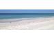 Expansive beach view with gentle waves and white sand, illustrating the proximity to the ocean at 10355 Paradise Blvd # 412, Treasure Island, FL 33706