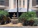 Elegant building entrance with covered awning, water fountain and lush landscaping at 10355 Paradise Blvd # 412, Treasure Island, FL 33706